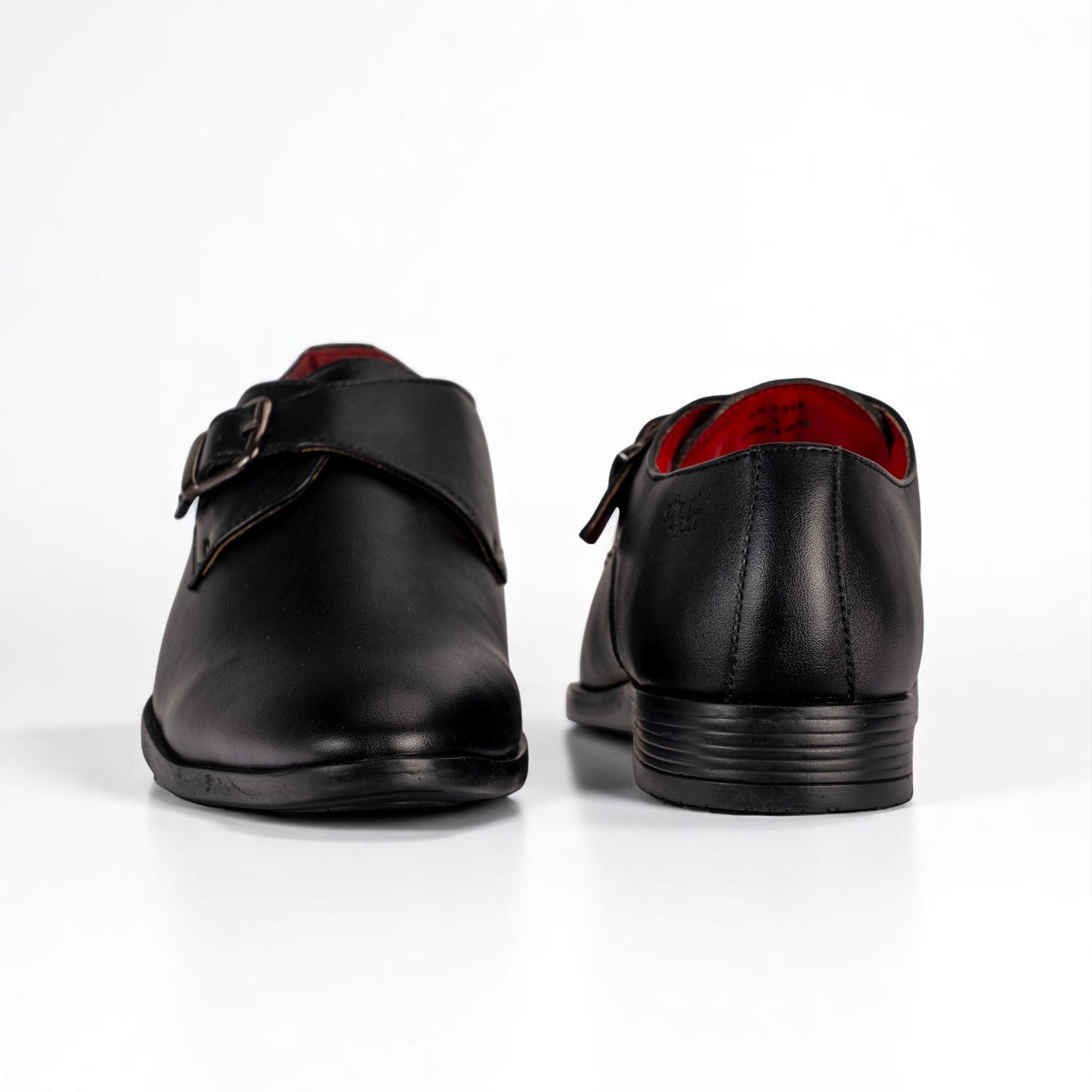 Black leather shoes with a strap on a white background