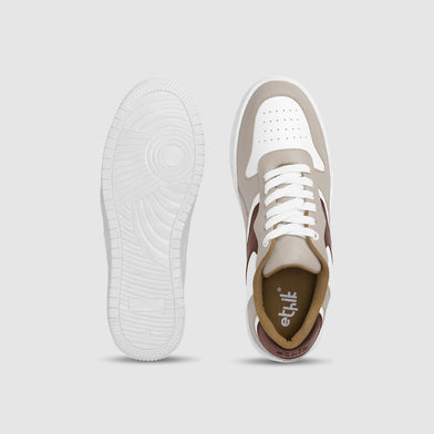 White and brown sneaker with visible brand logo on a light gray background