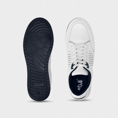 White sneaker with black sole on a light gray background