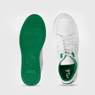 White sneaker with green sole and green accents on a light gray background