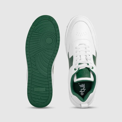 White sneakers with green soles and lining on a light gray background