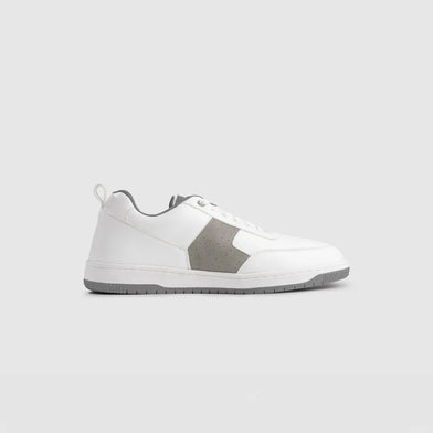 White sneaker with gray sole on a light gray background