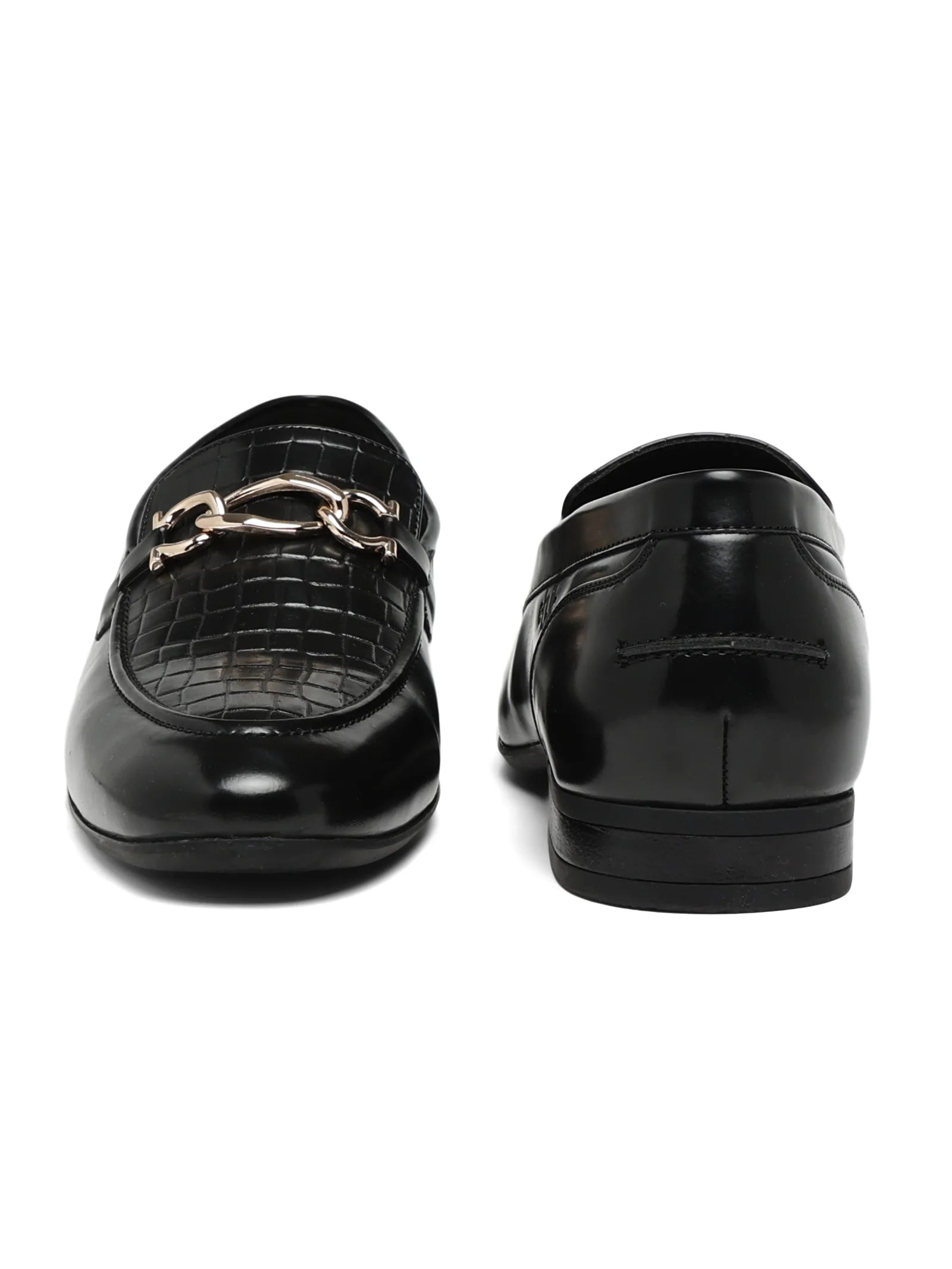Black loafers with gold chain detail on a white background