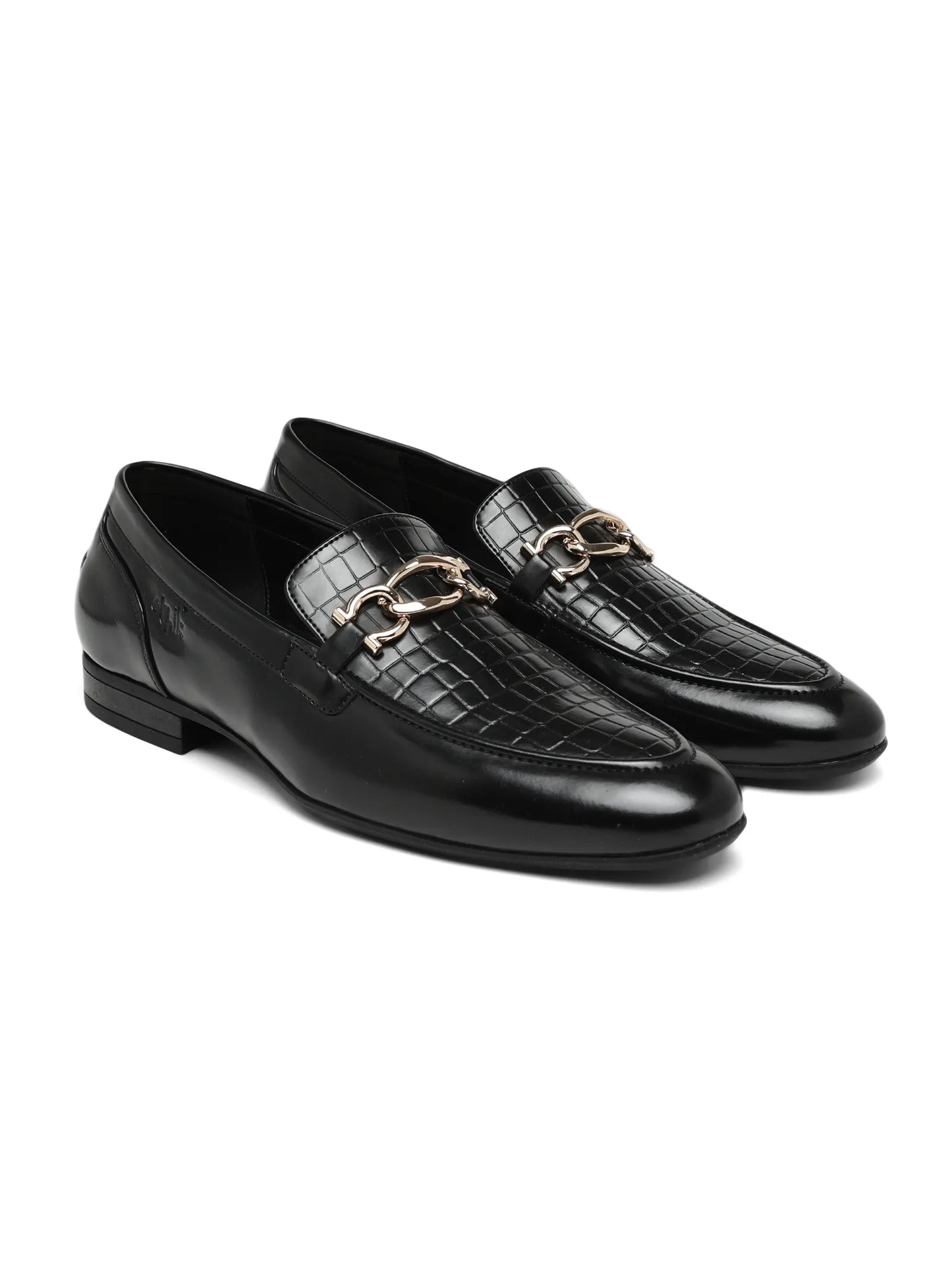 Black loafers with gold accents on a white background