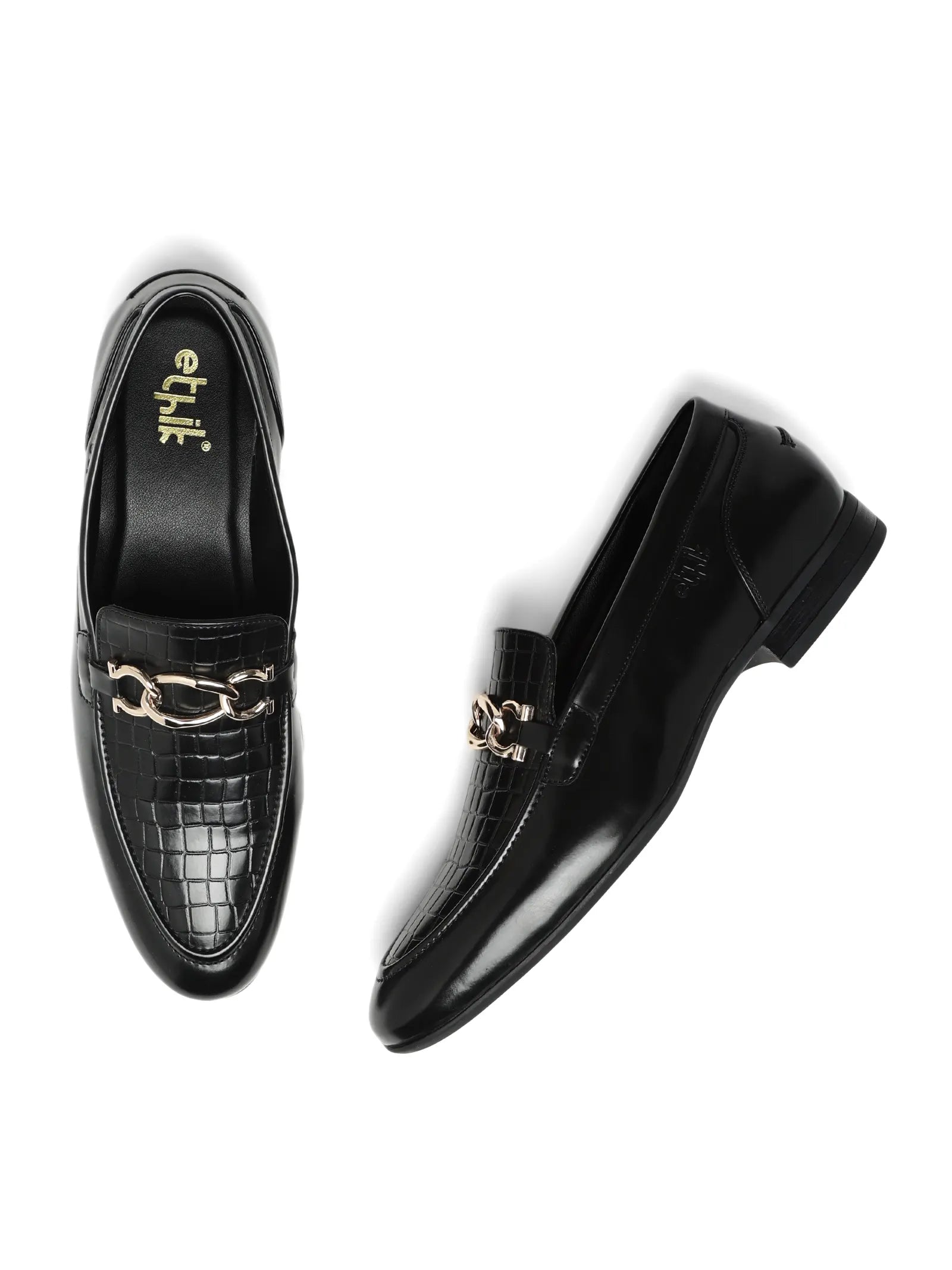 Black dress shoes with gold chain details on a white background