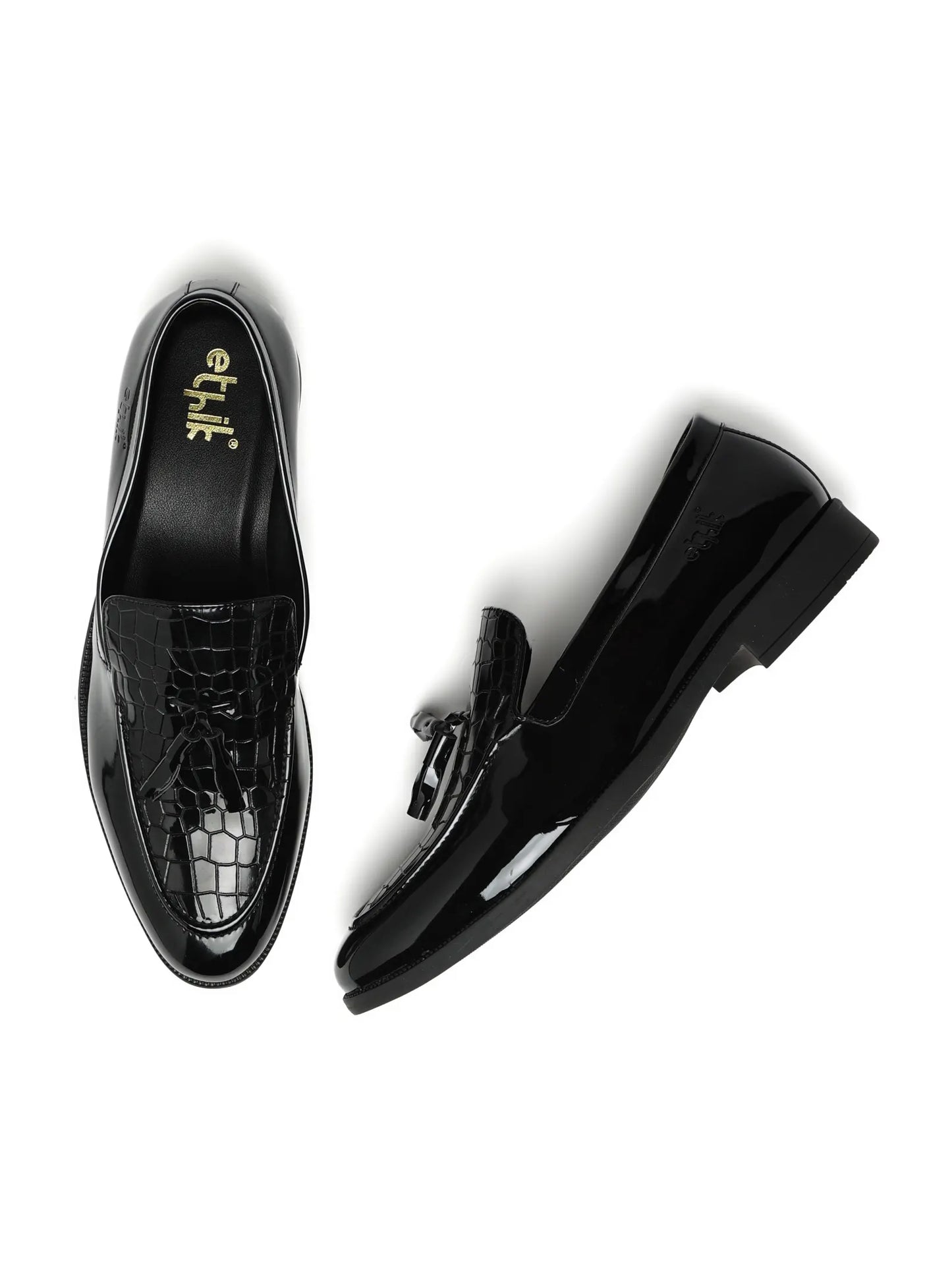 Black patent leather shoes with crocodile texture on a white background