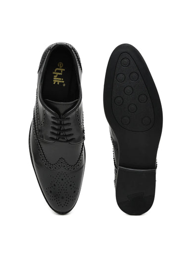Black leather dress shoes with brogue detailing on a white background