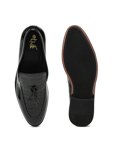 Black loafers with crocodile texture on a white background
